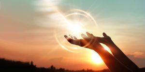 Woman hands praying for blessing from god on sunset background