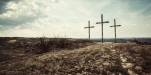 Big wooden cross above small city; burned dry land around; apocalyptic look;